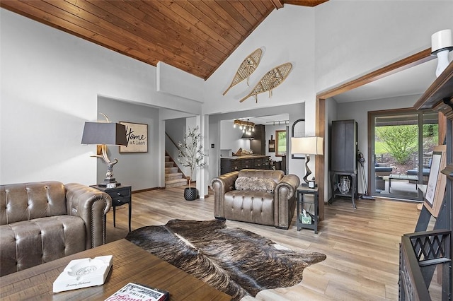living area featuring stairs, light wood-style flooring, high vaulted ceiling, wood ceiling, and baseboards