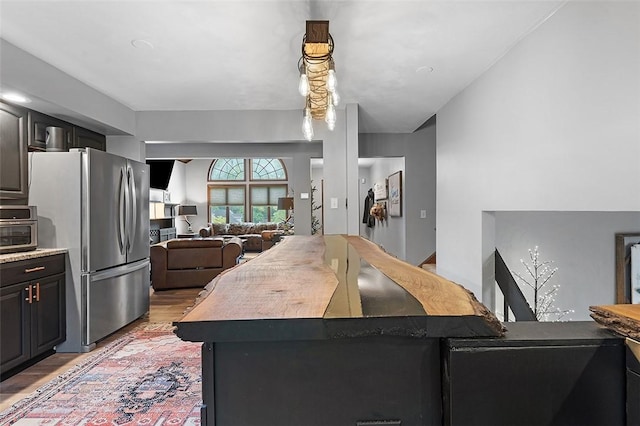 kitchen with freestanding refrigerator, light wood-style flooring, open floor plan, and a center island