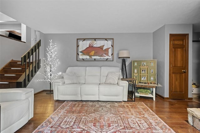 living area with stairs, wood finished floors, and baseboards