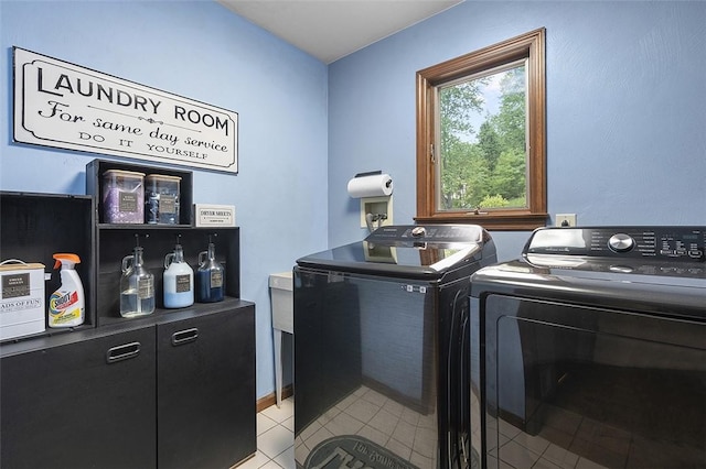 laundry area with washing machine and clothes dryer and light tile patterned flooring