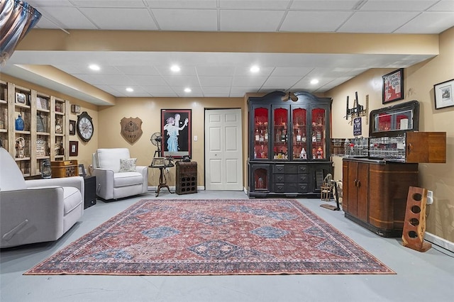 living area featuring a drop ceiling and recessed lighting
