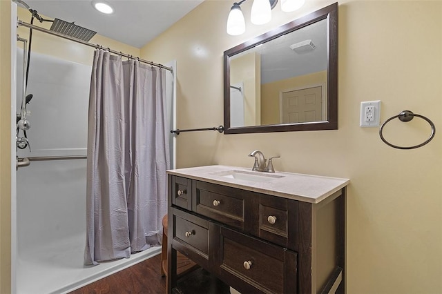 bathroom with a shower with shower curtain, vanity, and wood finished floors