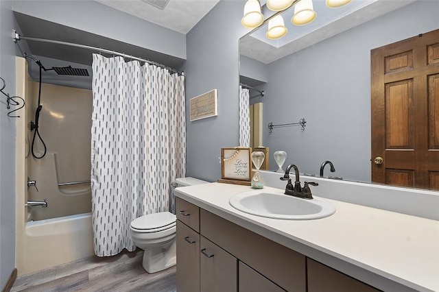bathroom featuring wood finished floors, toilet, vanity, a chandelier, and shower / tub combo with curtain