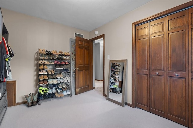 spacious closet featuring light colored carpet