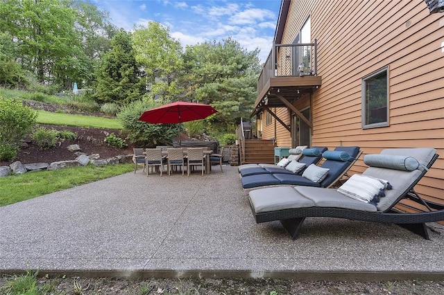 view of patio featuring a balcony, stairway, and outdoor dining area