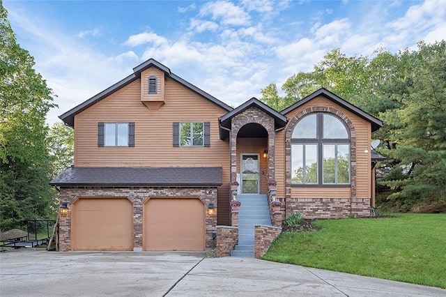 view of front facade with a front yard, brick siding, driveway, and an attached garage