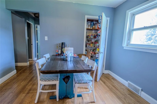 dining space with wood finished floors and baseboards