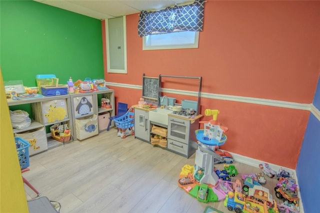 game room with wood finished floors and electric panel