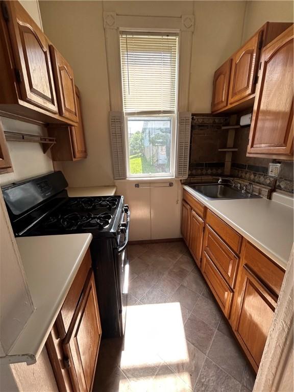 411 Cherry St, City Of But Ne, PA 16001 - kitchen with gas range, brown cabinets, and light countertops