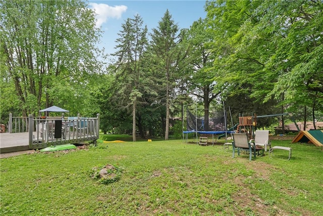 142 Meadowbrook Dr, Moon/Crescent Twp, PA 15108 - view of green lawn with a trampoline, a deck, and view of scattered trees