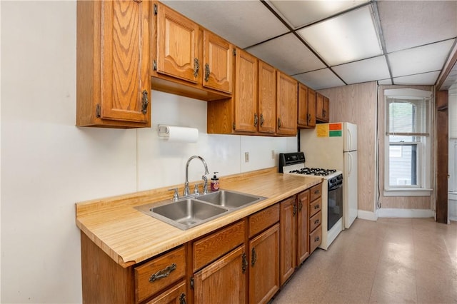 250 E Neshannock Ave, New Wilmington Boro, PA 16142 - kitchen with white range with gas cooktop, a sink, brown cabinetry, light countertops, and a paneled ceiling