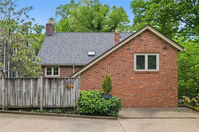 1017 Lancaster Ave, Regent Square, PA 15218 - view of front facade with a chimney, brick siding, and roof with shingles