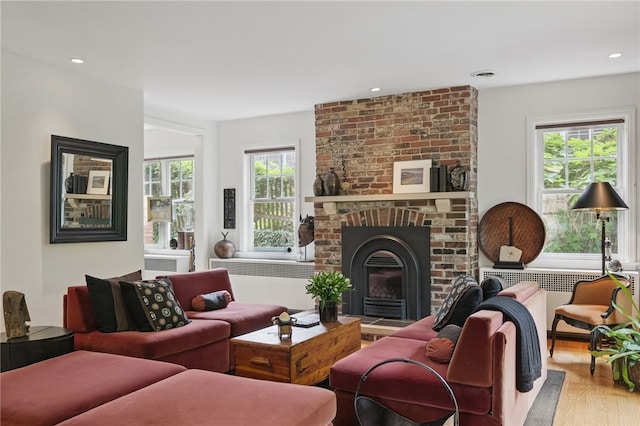 1017 Lancaster Ave, Regent Square, PA 15218 - living room with wood finished floors, a brick fireplace, recessed lighting, and radiator heating unit