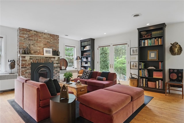 1017 Lancaster Ave, Regent Square, PA 15218 - living room with radiator heating unit, light wood finished floors, a fireplace, and recessed lighting
