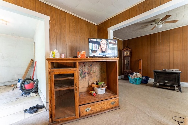6071 Rte 711, Saint Clair Twp, PA 15944 - detailed view of a wood stove, wooden walls, a ceiling fan, carpet, and ornamental molding