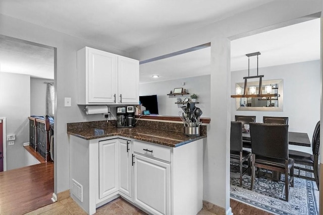 815 Semple Ave, Avalon, PA 15202 - kitchen featuring white cabinetry, dark stone countertops, pendant lighting, and a peninsula