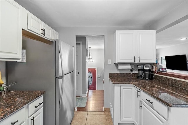 815 Semple Ave, Avalon, PA 15202 - kitchen featuring white cabinets, light tile patterned flooring, dark stone counters, and freestanding refrigerator