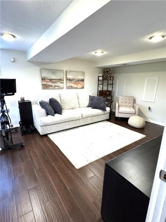 815 Semple Ave, Avalon, PA 15202 - living area with dark wood-type flooring, a textured ceiling, and baseboards