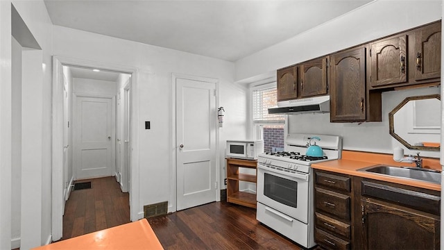 427 W Warrington Ave, Beltzhoover, PA 15210 - kitchen featuring white appliances, under cabinet range hood, dark brown cabinets, and dark wood-style flooring
