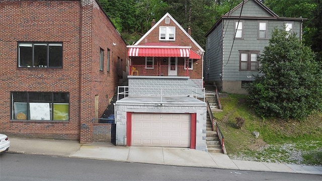427 W Warrington Ave, Beltzhoover, PA 15210 - view of front facade with brick siding, a garage, concrete driveway, and stairs