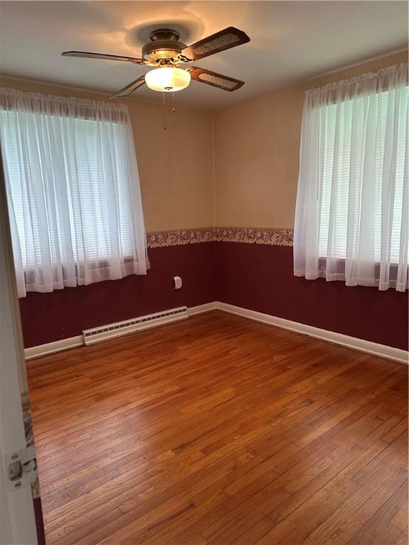 141 Mar Vel Dr, Center Twp But, PA 16001 - empty room featuring a baseboard heating unit, ceiling fan, wood finished floors, and baseboards