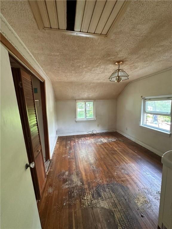 2905 Blackridge Ave, Penn Hills, PA 15235 - unfurnished room featuring a textured ceiling, wood-type flooring, vaulted ceiling, healthy amount of natural light, and baseboards