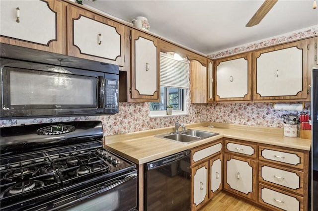 563 Meadowvale Dr, Cheswick, PA 15024 - kitchen with black appliances, a sink, light countertops, light wood-style flooring, and wallpapered walls