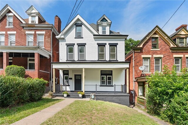 5415 Black St, East Liberty, PA 15206 - view of front of property with brick siding, a front lawn, and a porch