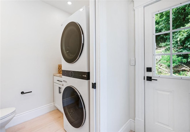 5415 Black St, East Liberty, PA 15206 - washroom featuring stacked washer / drying machine, healthy amount of natural light, light wood-type flooring, and baseboards