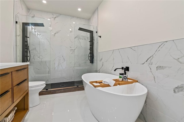 5415 Black St, East Liberty, PA 15206 - bathroom featuring tile walls, a marble finish shower, a soaking tub, vanity, and recessed lighting