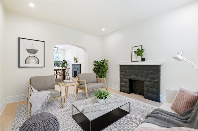 5415 Black St, East Liberty, PA 15206 - living area with a fireplace, arched walkways, light wood-style floors, baseboards, and recessed lighting