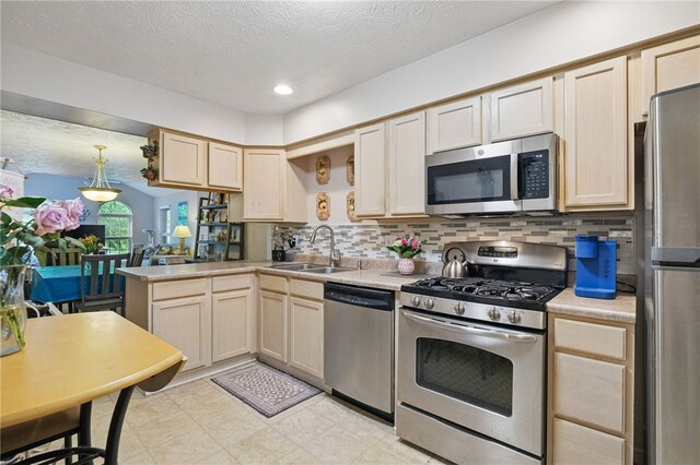 146 Barrington Dr, Collier Twp, PA 15071 - kitchen featuring appliances with stainless steel finishes, a sink, a peninsula, light countertops, and decorative backsplash