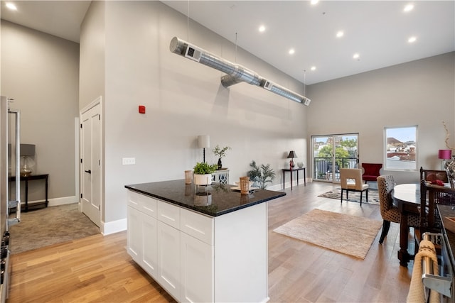 3809 Liberty Ave Unit 403, Lawrenceville, PA 15201 - kitchen featuring a towering ceiling, light wood finished floors, white cabinets, recessed lighting, and open floor plan