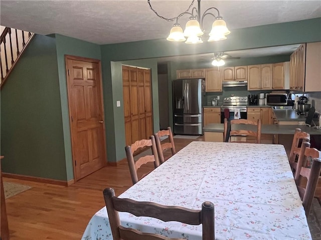 101 Pheasant Run Dr, Worth Twp But, PA 16057 - dining room featuring a chandelier, wood finished floors, ceiling fan, baseboards, and stairway