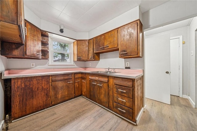 1725 Arlington Ave, South Side, PA 15210 - kitchen with light wood-type flooring, a sink, open shelves, light countertops, and brown cabinets