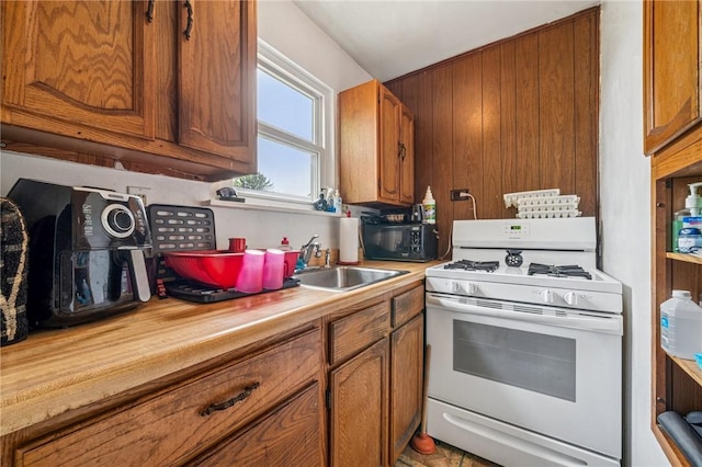 1725 Arlington Ave, South Side, PA 15210 - kitchen with white range with gas stovetop, a sink, brown cabinets, and black microwave