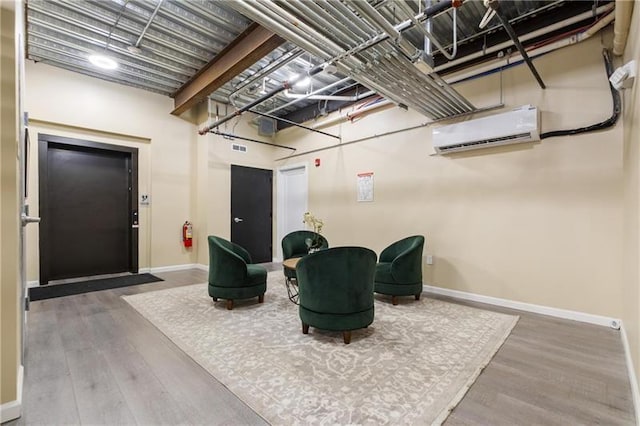 3809 Liberty Ave Unit 302, Lawrenceville, PA 15201 - sitting room with a wall mounted AC, baseboards, and wood finished floors