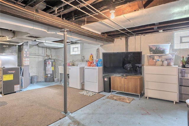 basement featuring gas water heater, washing machine and clothes dryer, and heating unit