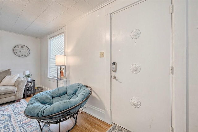 entrance foyer with light wood-style flooring, crown molding, and baseboards