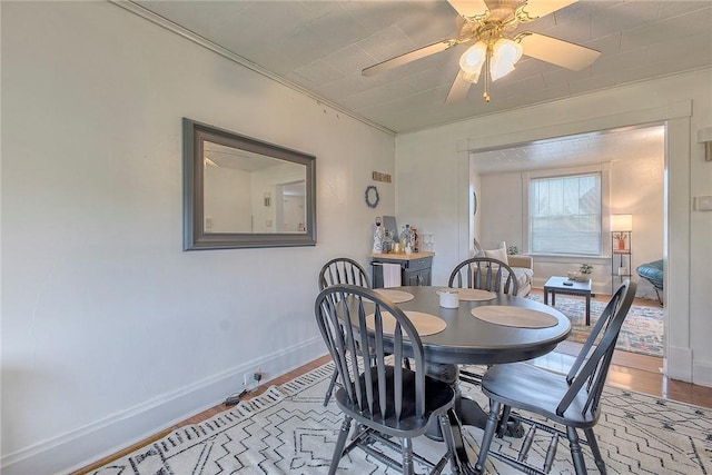 dining space featuring light wood-type flooring, ceiling fan, and baseboards