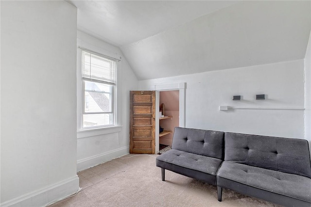 living area featuring vaulted ceiling, carpet flooring, and baseboards