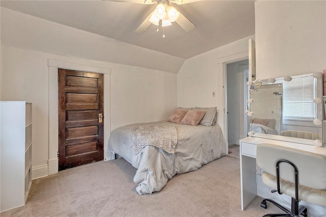 bedroom featuring light carpet, lofted ceiling, a desk, and ceiling fan
