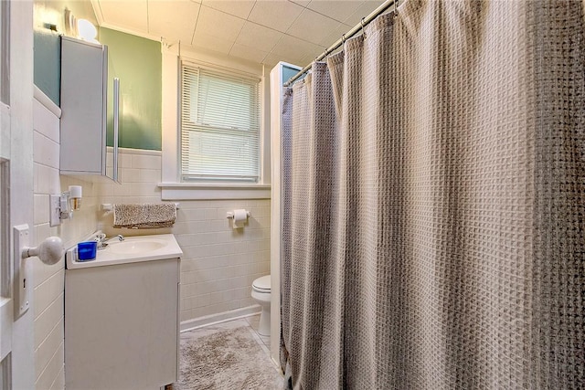 full bath with tile walls, toilet, and vanity