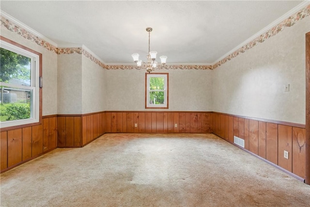 2703 Conway Wallrose Rd, Economy, PA 15005 - spare room featuring a chandelier, a wainscoted wall, wood walls, ornamental molding, and carpet flooring