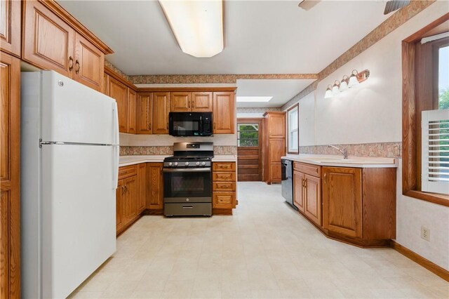 2703 Conway Wallrose Rd, Economy, PA 15005 - kitchen with freestanding refrigerator, black microwave, gas stove, light countertops, and dishwasher