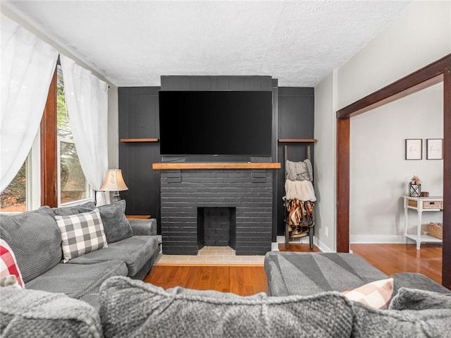 258 Wayne St, Baden, PA 15005 - living room with wood finished floors, a fireplace, a textured ceiling, and baseboards