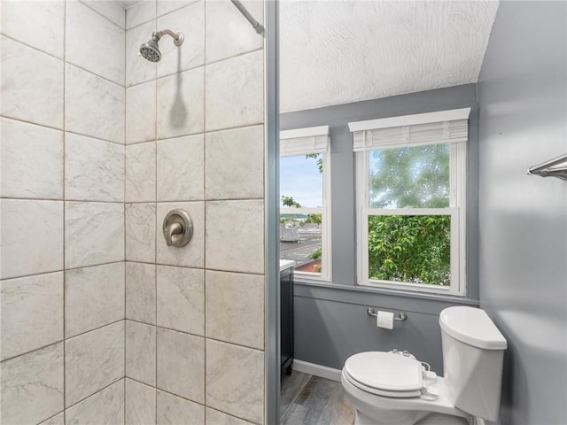 258 Wayne St, Baden, PA 15005 - full bath with tiled shower, wood finished floors, toilet, and baseboards