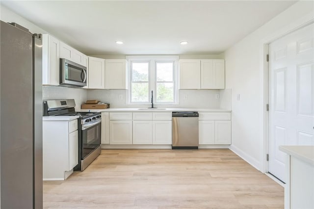 3510 Middletown Rd, Crafton Heights, PA 15204 - kitchen featuring stainless steel appliances, a sink, light countertops, light wood-style floors, and white cabinets