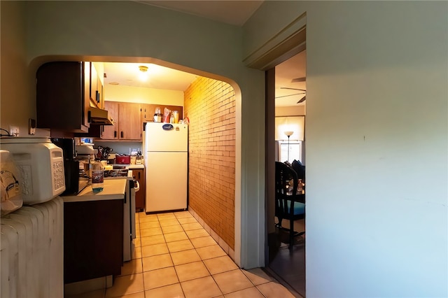 422 Hays Ave, Mount Oliver, PA 15210 - kitchen with freestanding refrigerator, under cabinet range hood, stainless steel range with gas stovetop, light countertops, and arched walkways