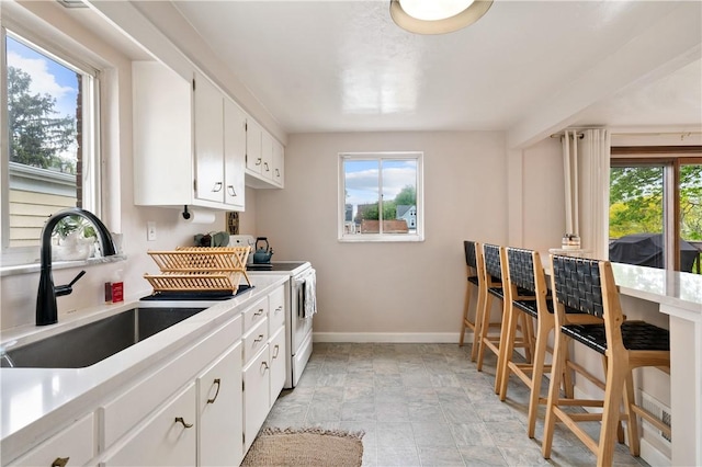 2351 Saranac Ave, Beechview, PA 15216 - kitchen with white range with electric stovetop, a sink, baseboards, and light countertops
